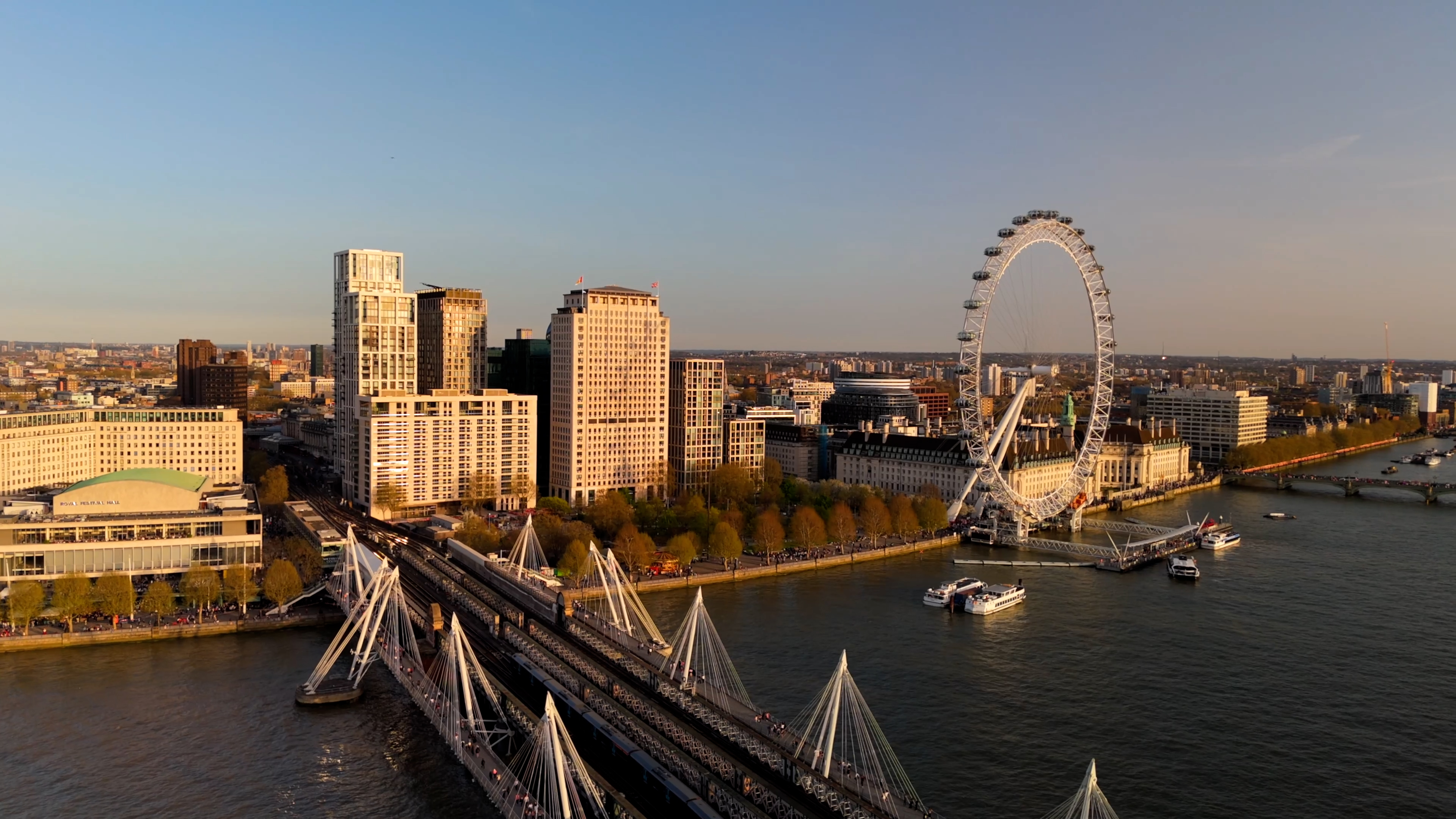 Golden hour aerial view of the City of London skyline from Canary Wharf, with the Thames below